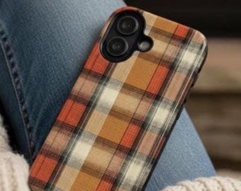 May include: A rectangular smartphone case featuring a plaid pattern in shades of orange, brown, cream, and black. The case has a black camera cutout area at the top left corner, designed to accommodate two circular camera lenses and a flash component.