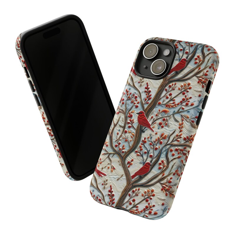 May include: A white phone case with a wintery design featuring red cardinals perched on branches with red berries. The case has a raised, textured design and a black camera lens cutout.