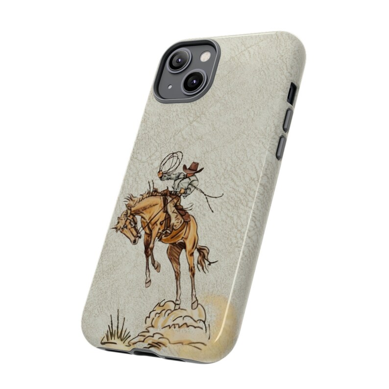 May include: A phone case with a beige background and a drawing of a cowboy riding a horse. The cowboy is wearing a brown hat and a brown shirt. The horse is brown and white.