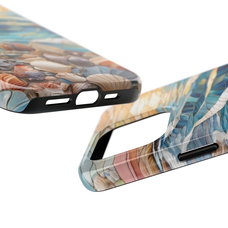 May include: Two phone cases featuring a beach-themed design. One case displays a collection of seashells on sand, while the other shows a blue and gold abstract pattern resembling water. Both cases have black edges and precise cutouts for ports.