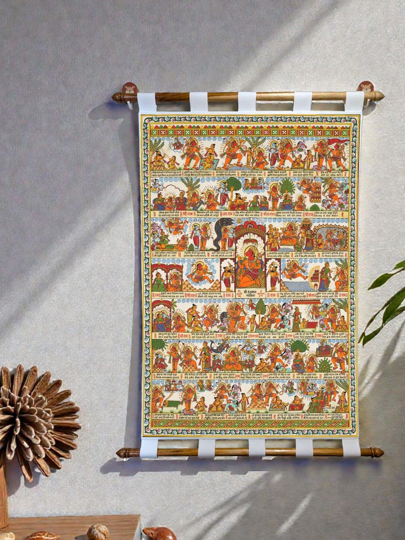 May include: A vibrant wall hanging with a detailed illustration of religious figures and scenes. The artwork is mounted on wooden dowels with white fabric straps. The illustration uses shades of orange, yellow, green, and blue, creating a detailed narrative.