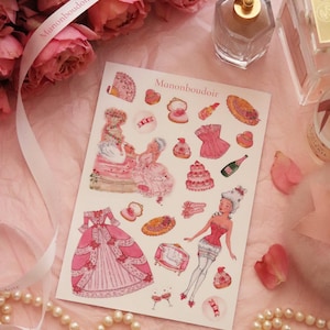 May include: A sheet of stickers with a vintage theme, featuring illustrations of dresses, cakes, and ladies in pink and red. The stickers are arranged on a pink surface with roses, perfume, and a pearl necklace.
