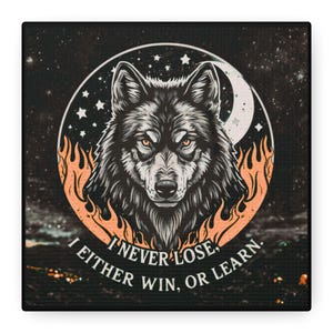 May include: Square canvas art featuring a detailed illustration of a wolf's head within a circular design. The wolf is black and gray with orange eyes, surrounded by flames and a crescent moon. The text reads, "I NEVER LOSE, I EITHER WIN, OR LEARN."