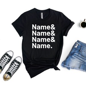 Op de afbeelding: Zwart T-shirt met witte tekst die "Name & Name & Name & Name." luidt.
