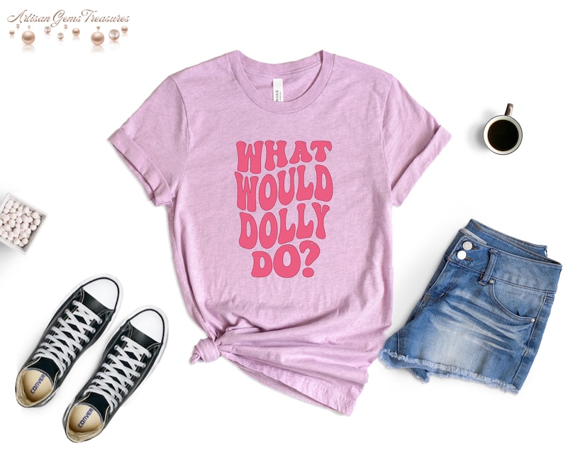 May include: A pink t-shirt with the text "What Would Dolly Do?" in pink retro-style lettering.
