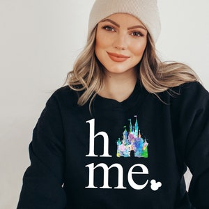 Puede incluir: Sudadera negra con un gr&aacute;fico blanco de un castillo y el texto "home" y "me" con un peque&ntilde;o icono de Mickey Mouse.