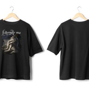 May include: Black t-shirt with the text "Literally me" above a graphic of a wolf-like creature. The shirt is displayed on a wooden hanger against a white background. The back of the shirt is also visible.