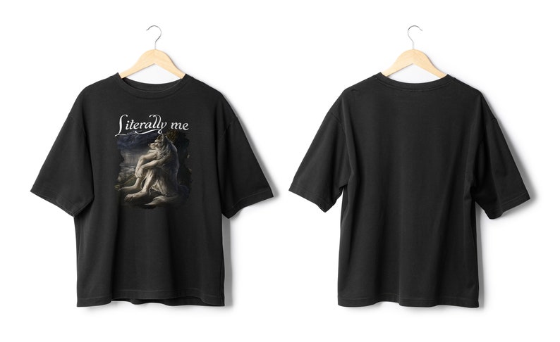 May include: Black t-shirt with the text "Literally me" above a graphic of a wolf-like creature. The shirt is displayed on a wooden hanger against a white background. The back of the shirt is also visible.