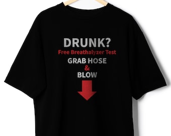 May include: Black t-shirt with the text "DRUNK? Free Breathalyzer Test GRAB HOSE & BLOW" in white, red, and gray. A red arrow points downward. The shirt is hanging on a wooden hanger.