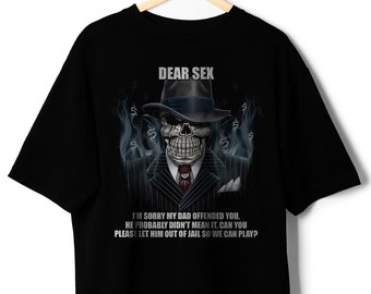 May include: Black t-shirt with a graphic of a skull wearing a fedora and pinstripe suit. The text "DEAR SEX" is above the skull. Below the skull is the text: "I'M SORRY MY DAD OFFENDED YOU, HE PROBABLY DIDN'T MEAN IT, CAN YOU PLEASE LET HIM OUT OF JAIL SO WE CAN PLAY?"