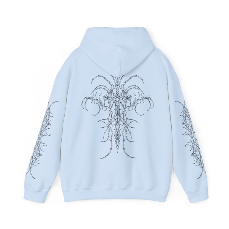 Pu&ograve; includere: Una felpa con cappuccio blu chiaro con un design grafico in bianco e nero sul retro e sulle maniche. Il design presenta una croce con dettagli intricati.