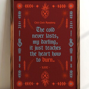 May include: Framed art print with a dark red background and a wooden frame. The print features a quote in blue and orange text, surrounded by decorative floral and geometric designs. The text reads "The cold never lasts, my darling, it just teaches the heart how to burn."