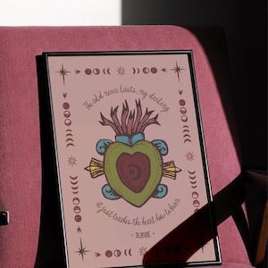 May include: Framed art print featuring a heart design with a central heart shape, surrounded by a green and blue outline. The artwork includes text that reads "The old never lasts, my darling, it just teaches the heart how to burn." The print is in a black frame.