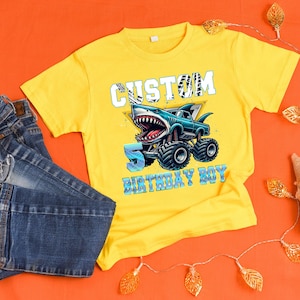 May include: Yellow t-shirt with a blue monster truck graphic and the text "Custom 5 Birthday Boy".
