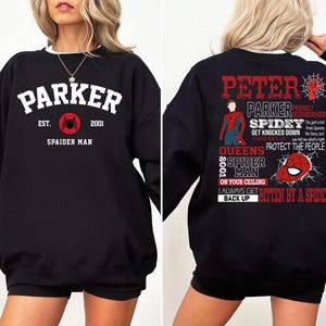 May include: Black sweatshirt with a white graphic print of a spider and the text "Parker Est. 2001 Spaider Man".