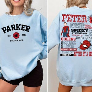 May include: Light blue sweatshirt with a black and red Spider-Man graphic and the text "Parker Est. 2001 Spaider Man" on the front. The back of the sweatshirt has the text "Peter Parker Friendly Neighborhood Spidey Get Knocked Down Stand Back Up Queens 2001 Spider Man On Your Ceiling I Always Get Back Up Bitten By A Spider".