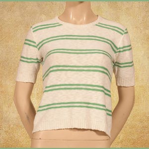 May include: A white and green striped short-sleeved shirt with a crew neck.
