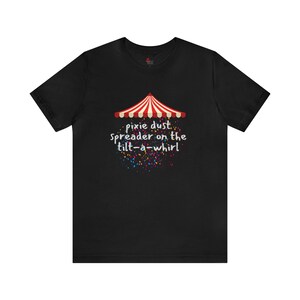 May include: Black t-shirt featuring a red and white striped carnival tent graphic and the text "pixie dust spreader on the tilt-a-whirl".