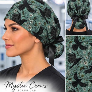 Può includere: Una cuffia chirurgica con sfondo verde acqua e un motivo ripetuto di corvi neri e fiori bianchi. La cuffia include un nastro di raso nero sul retro per fissare i capelli e presenta un disegno dettagliato di viticci intrecciati.