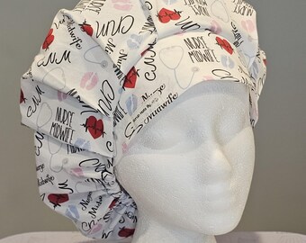 May include: White scrub hat with a repeating pattern of red hearts, baby footprints, lips, and stethoscopes. The words "Nurse Midwife" and "CNM" are also printed on the hat. The hat is displayed on a white mannequin head.