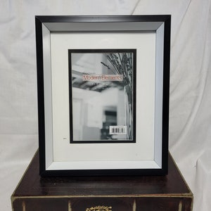 Black and White Plastic Hanging or Free Standing Frame with White Matte Trimmed in Black