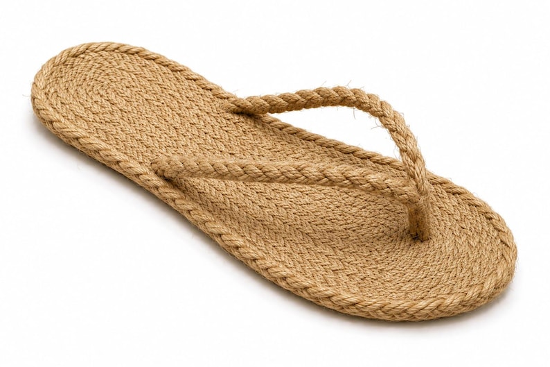 May include: A single flip-flop sandal constructed entirely from tan-colored braided rope. The flat sole features a coiled rope design, while the Y-shaped toe post strap is made from a matching twisted rope material, creating a textured appearance.