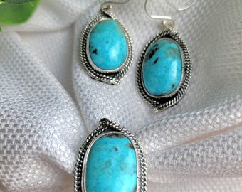 May include: A set of turquoise earrings and a ring with silver settings. The turquoise stones are a vibrant blue-green color and have a unique pattern.