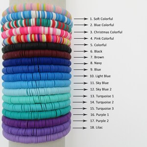 Pode incluir: Uma pilha de 18 pulseiras coloridas feitas de pequenas contas redondas. As pulseiras est&atilde;o organizadas por cor, do suave colorido ao lil&aacute;s. As cores incluem rosa, vermelho, verde, azul, turquesa, roxo e preto.