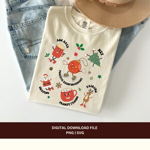 May include: A beige t-shirt with a Christmas-themed design featuring a red mug, a red ornament, a Santa Claus, a reindeer, and a Christmas tree. The design includes the text "ABC DATA", "NET", "POSITIVE REINFORCEMENT", "PROMPT FADING", "SHAPING", and "PAIRING".