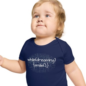 May include: A navy blue baby onesie with a white graphic that reads "while(dreaming){smile();}"