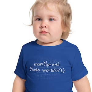 May include: A toddler wearing a royal blue t-shirt with a white graphic of code that reads "main(){printf('hello, world
');}"