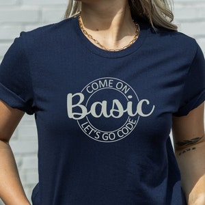 May include: A navy blue t-shirt with a white circle graphic that says "Come on Basic Let's Go Code".