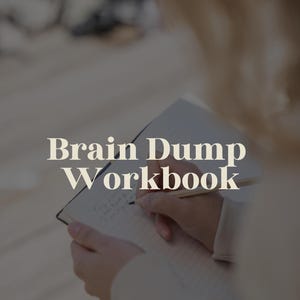 Könnte beinhalten: Eine Person schreibt in ein Notizbuch mit dem Text "Brain Dump Workbook" auf dem Cover.
