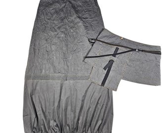 May include: A grey skirt with a matching attached pocket. The skirt has a textured, wrinkled appearance on the upper section and a smooth lower section. The pocket has the number "1" printed on it.