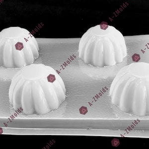 May include: A white, fluted mold with four dome-shaped cavities. The mold is made of a clear, flexible material, and is designed for creating desserts or decorative items. The mold is labeled with the text "A-Z Molds".