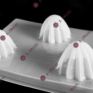 May include: A white silicone mold with three dome-shaped cavities. The mold is designed for making cake pops or other small treats.