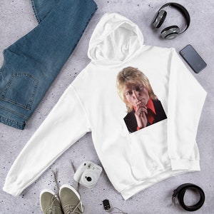 May include: White hooded sweatshirt with a graphic print of a man with blonde hair wearing a red and black shirt.
