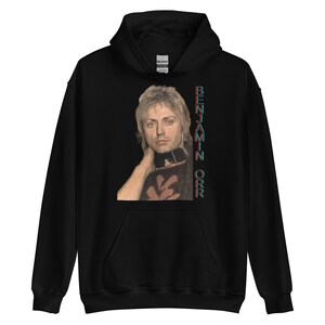 May include: Black hooded sweatshirt with a photo of a man with blonde hair and a black choker. The text "BENJAMIN ORR" is printed vertically on the right side of the image.