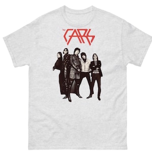 May include: A grey t-shirt with a red graphic of the band "The Cars" with the band members in black and white behind the text.