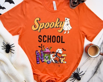 May include: Orange t-shirt with the text "Spooky School Nurse" in black and white. The word "Nurse" is decorated with Halloween-themed graphics, including a ghost, a cupcake, and bats.