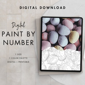 May include: Digital paint by number image of a pile of pastel colored candy eggs. The image is displayed on a tablet with a stylus next to it. The text "Digital Paint By Number" is displayed above the tablet.
