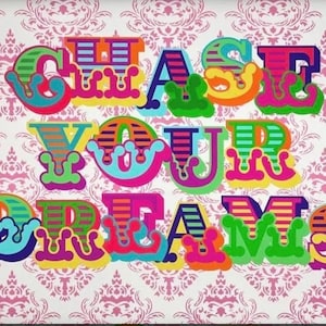 Könnte beinhalten: Buntfarbene, gestreifte Buchstaben, die "CHASE YOUR DREAMS" auf einem rosa-weißen gemusterten Hintergrund buchstabieren.