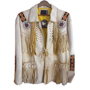 May include: White leather jacket with fringe and beaded details. The jacket has a yellow lining and a beaded design on the sleeves and collar.
