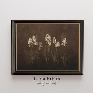 May include: A framed floral print featuring white hyacinth flowers against a dark brown background. The artwork is in a black frame with a gold inner border. The text "Luna Prints designer art" is at the bottom.
