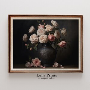 Puede incluir: Un ramo de rosas rosas y blancas en un jarr&oacute;n marr&oacute;n oscuro con tallas intrincadas. Las rosas est&aacute;n dispuestas en un estilo cl&aacute;sico, con algunos p&eacute;talos cayendo sobre la superficie de madera oscura debajo. La imagen est&aacute; enmarcada en un marco dorado.