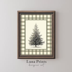 May include: Framed art print featuring a detailed illustration of a Christmas tree with lights. The tree is centered on a cream-colored background, framed by a green and white plaid pattern. The frame is a dark brown color. The text "Luna Prints designer art" is at the bottom.