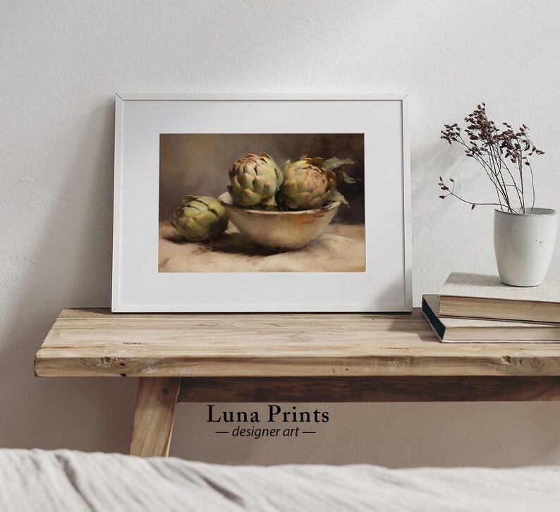 May include: A still life painting of three artichokes in a white bowl on a beige tablecloth. The artichokes are green and have a brown stem. The bowl is white and has a brown rim. The tablecloth is beige and has a brown pattern.