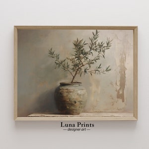 May include: A painting of a green olive branch in a brown ceramic pot against a textured, light blue and beige background. The painting is framed in a light wood frame. The text "Luna Prints - designer art" is at the bottom of the image.