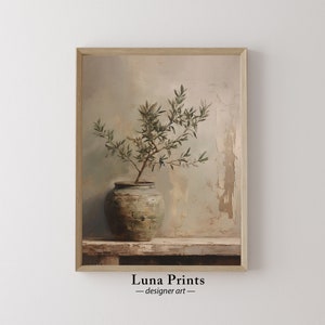 Könnte beinhalten: Ein Gemälde eines kleinen Olivenbaums in einem grünen Keramiktopf, vor einem strukturierten, hellbraunen Hintergrund. Der Baum hat grüne Blätter und Äste. Der Topf steht auf einem Holzregal.