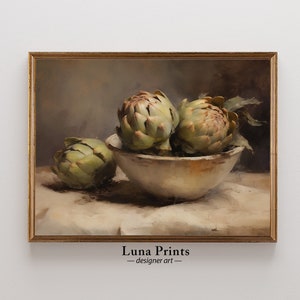 May include: A still life painting of three artichokes in a white bowl on a white tablecloth. The artichokes are green and have a brown hue. The painting is framed in a gold frame.